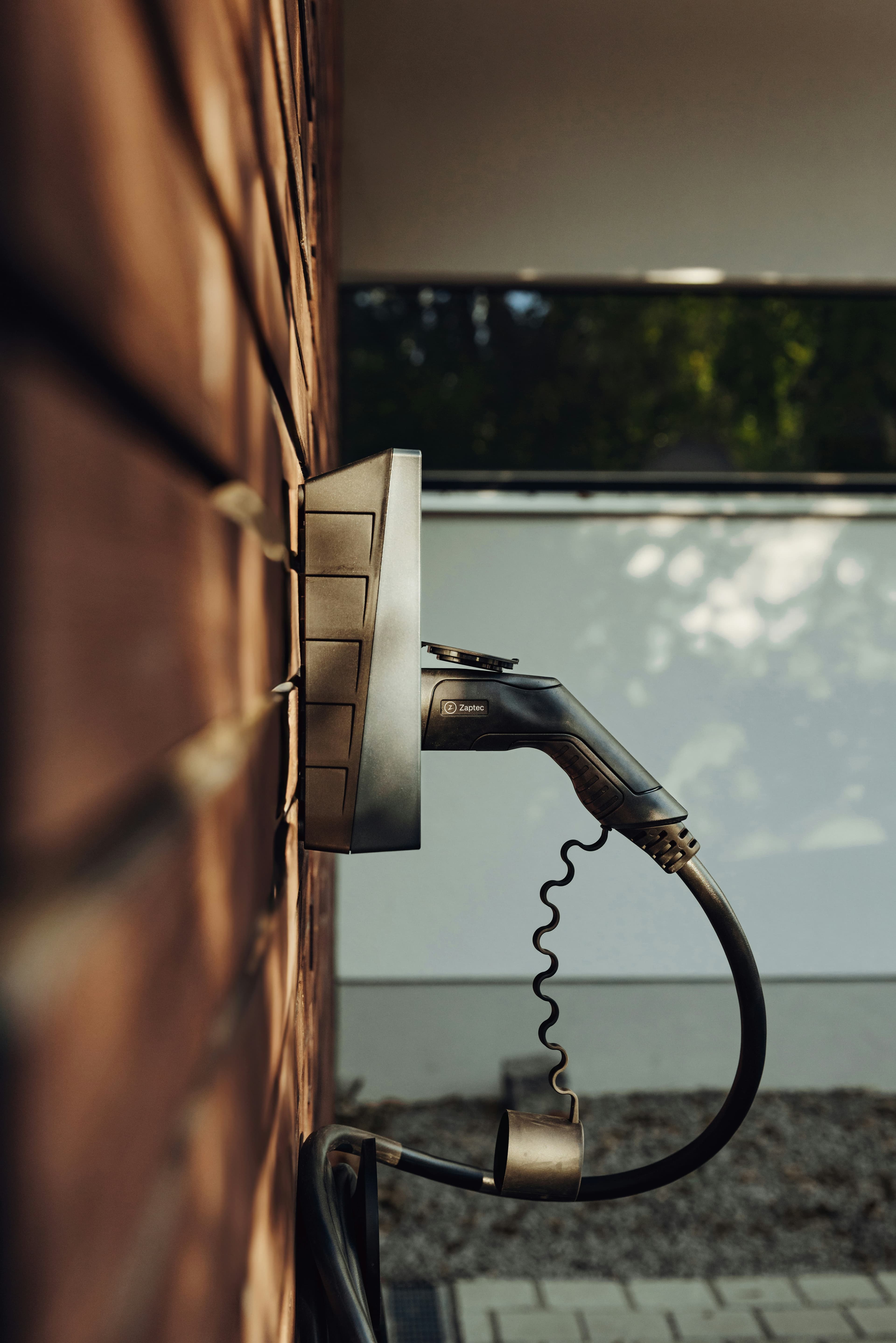 A sleek, modern electric vehicle charger mounted cleanly on a building facade