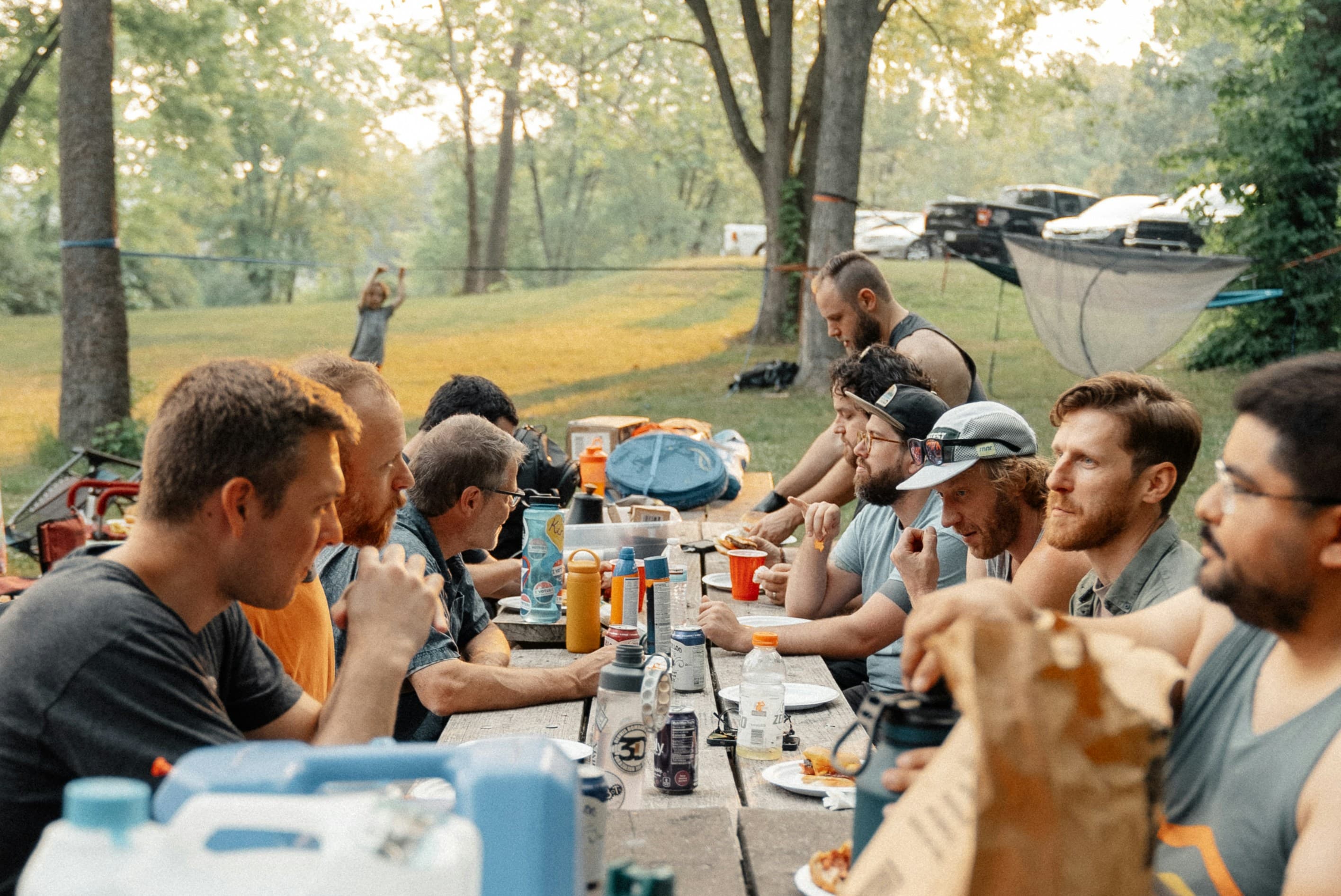 Family and friends gathered around an outdoor table, sharing a meal together